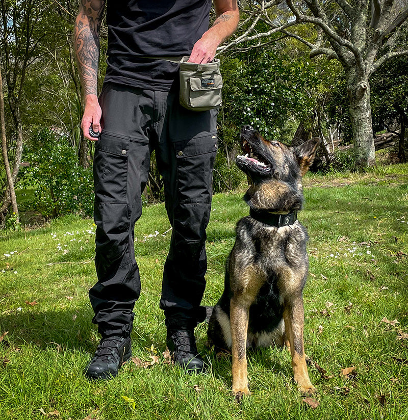 Handler using the Sabre Tactical K9 Food Reward Pouch during field training, featuring quick-access snap closure and secure fit for efficient K9 reward delivery.