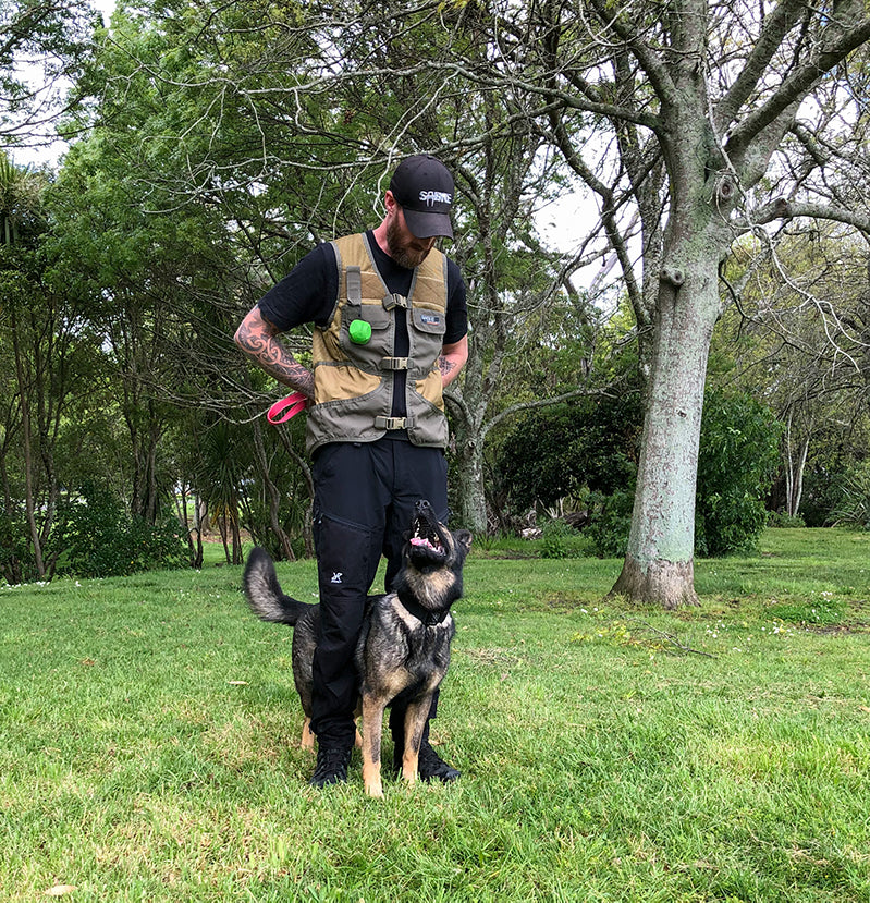Handler wearing the Sabre Tactical K9 Training Jacket during field training, utilising its accessible pockets and ergonomic design for efficient K9 training sessions.